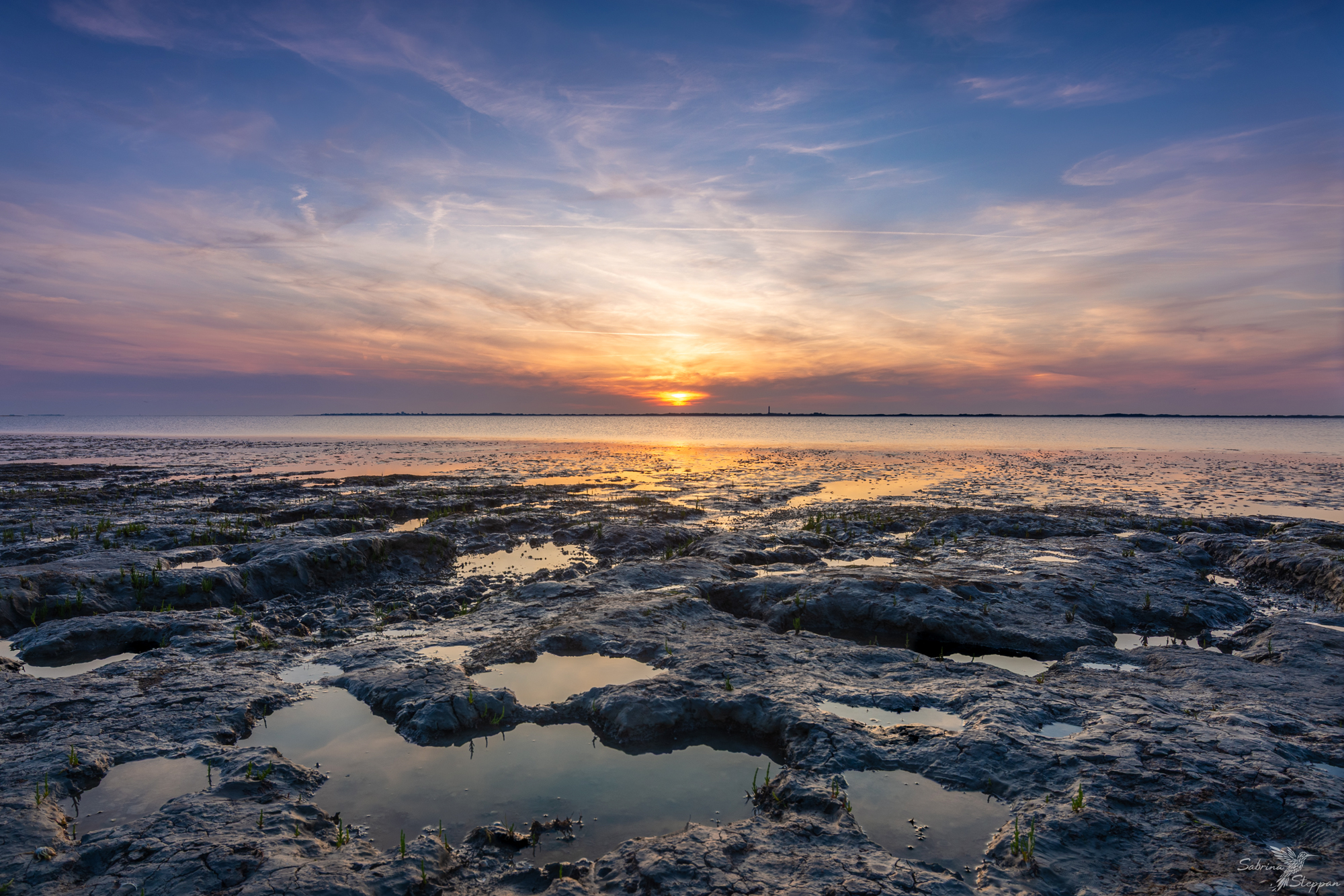 Wo das Abendlicht den Naturstrand berührt